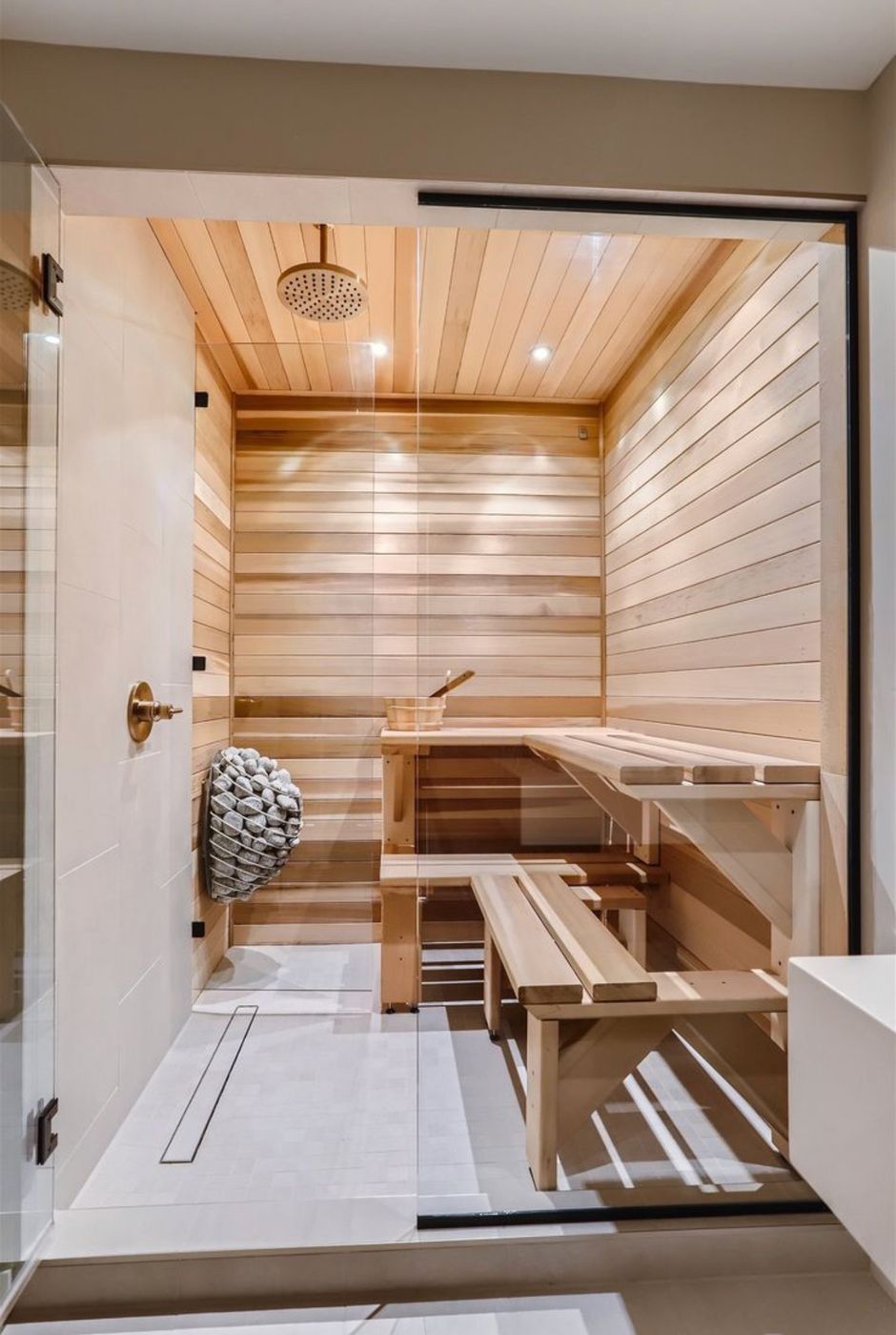 Spa bathroom with a glass-enclosed cedar sauna and tiled shower